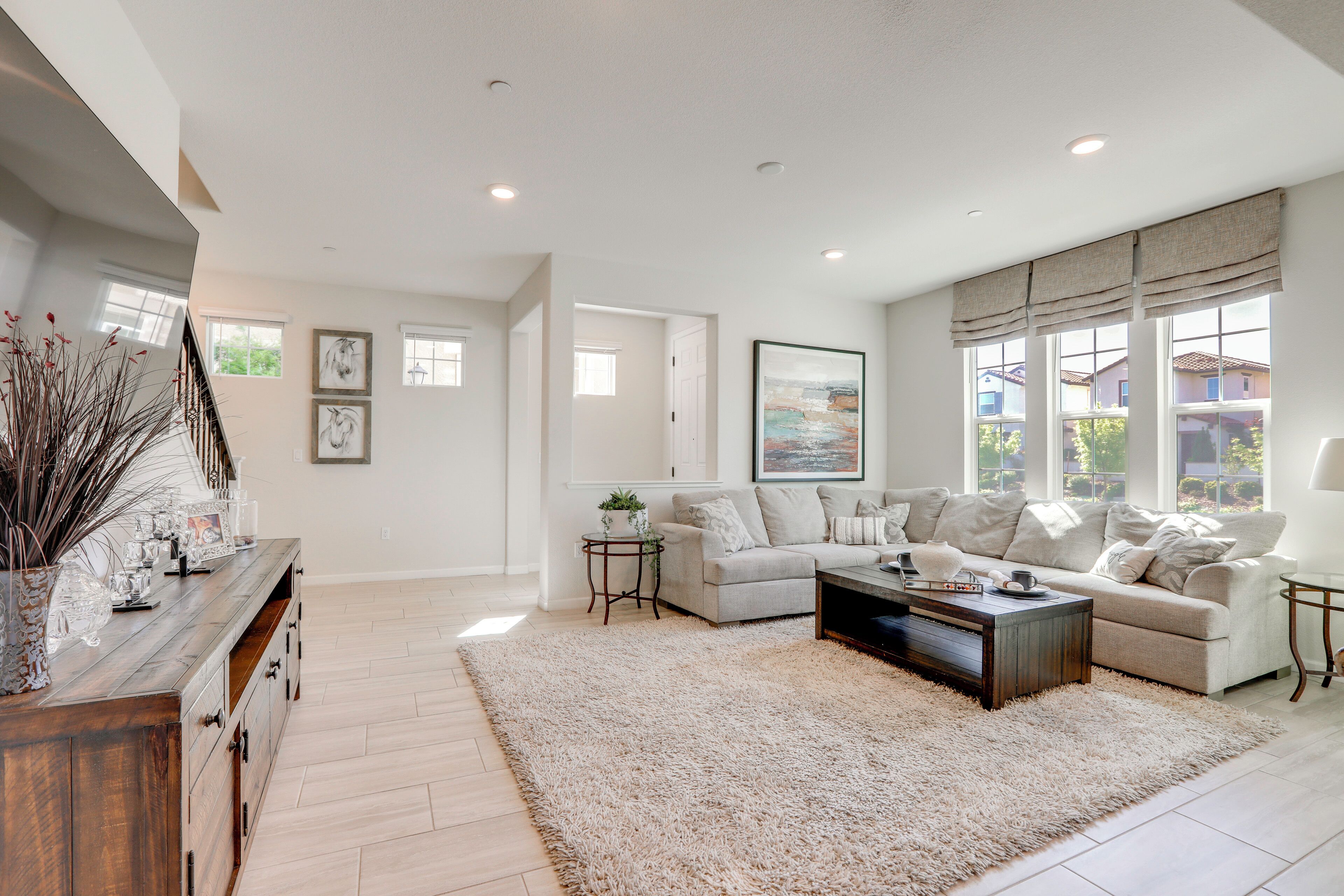 A spacious living room with a large sectional sofa, a coffee table, and a decorative rug.