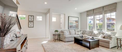 A spacious living room with a large sectional sofa, a coffee table, and a decorative rug.