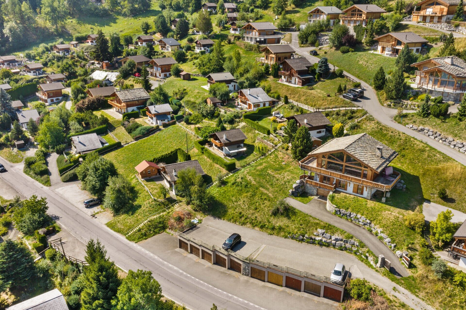 A residential area with multiple houses, roads, and a parking area.