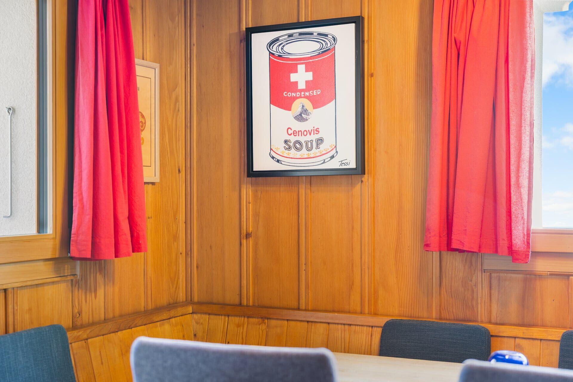 A framed advertisement for Condensed Cenovis Soup in a room with wooden paneling and red curtains.