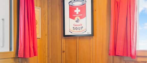 A framed advertisement for Condensed Cenovis Soup in a room with wooden paneling and red curtains.