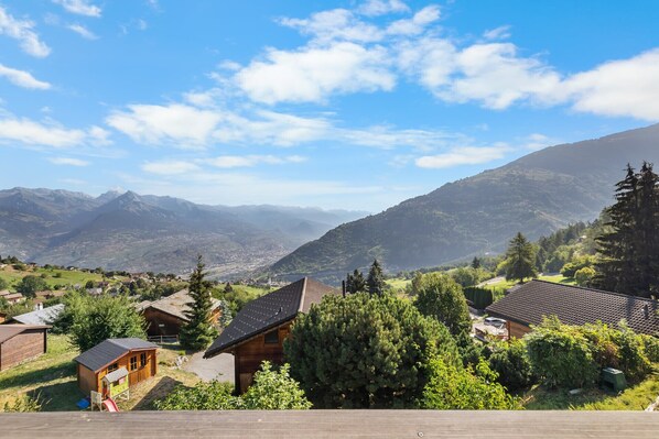 Un paysage montagneux parsemé de chalets en bois, sous un ciel dégagé.