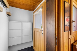 Ein Zimmer mit Holztür, weißem Schrank und einem Fenster.