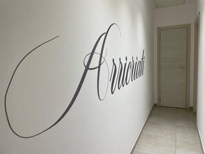 A hallway with a wall featuring the word 'Acquaintati' in a stylized font. - Arricriati near Ortigia by Wonderful Italy (Siracusa)