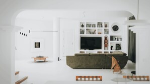 Un soggiorno moderno con una grande TV a schermo piatto, un divano e un tavolino.