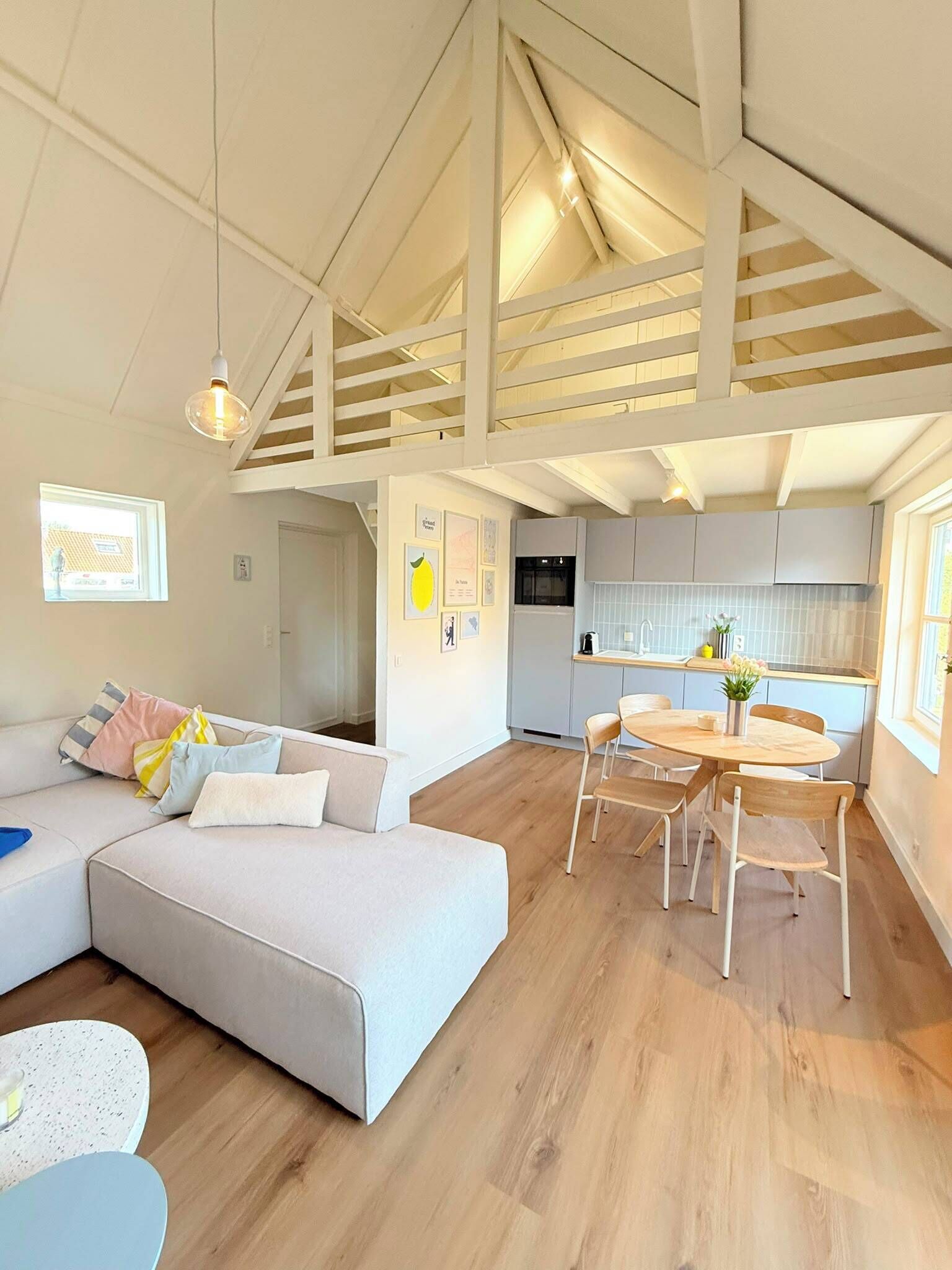 Un intérieur moderne comprenant un espace de vie, un coin repas et une cuisine.