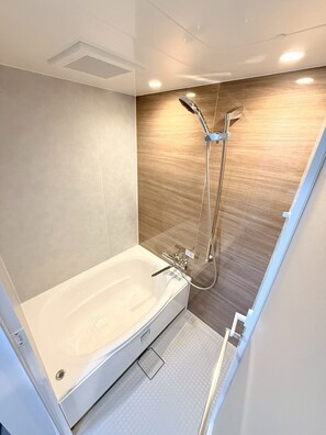 A modern bathroom with a freestanding bathtub, a glass-enclosed shower, and a wooden accent wall. - Hotel Starrise Nagasaki (Nagasaki)