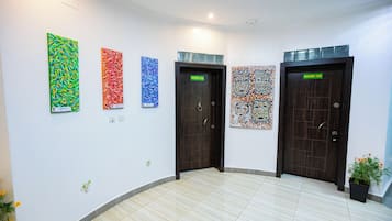 Un pasillo con cuatro puertas, cada una decorada con una obra de arte distinta.
