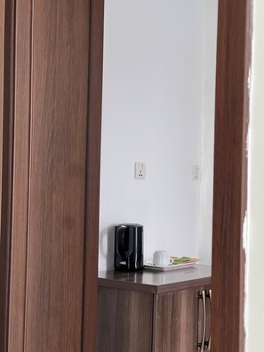 A wooden cabinet with a coffee maker and a cup on top. - Eagle View Kimi (Kigali)