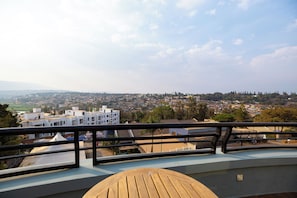A balcony with a view of a cityscape, including buildings and greenery. - Eagle View Kimi (Kigali)
