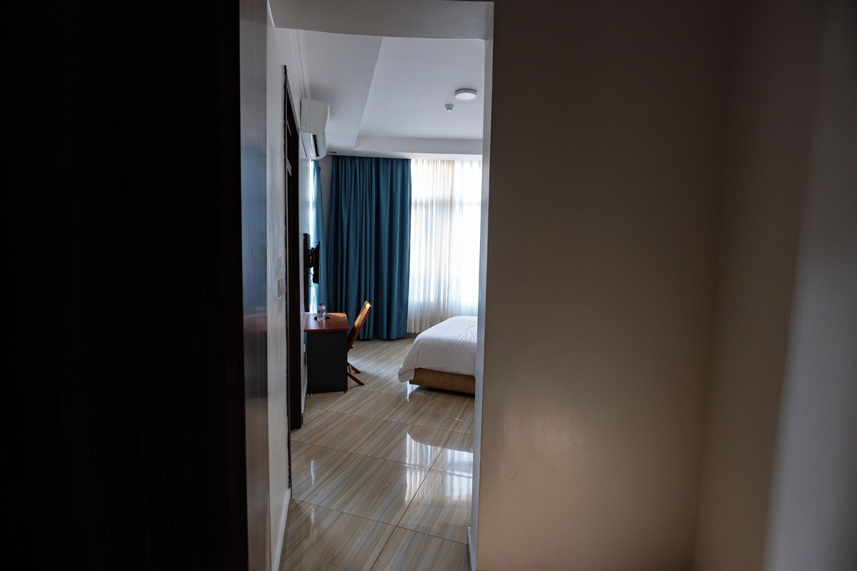 Ein Hotelzimmer mit einem Bett, einem Schreibtisch und einem Stuhl.