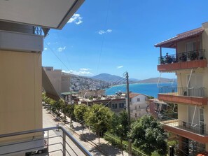 A residential area with a view of the sea, buildings with balconies, and a clear sky. - Exquisite Blue Breeze - Free Parking Apartment (Sarandë)