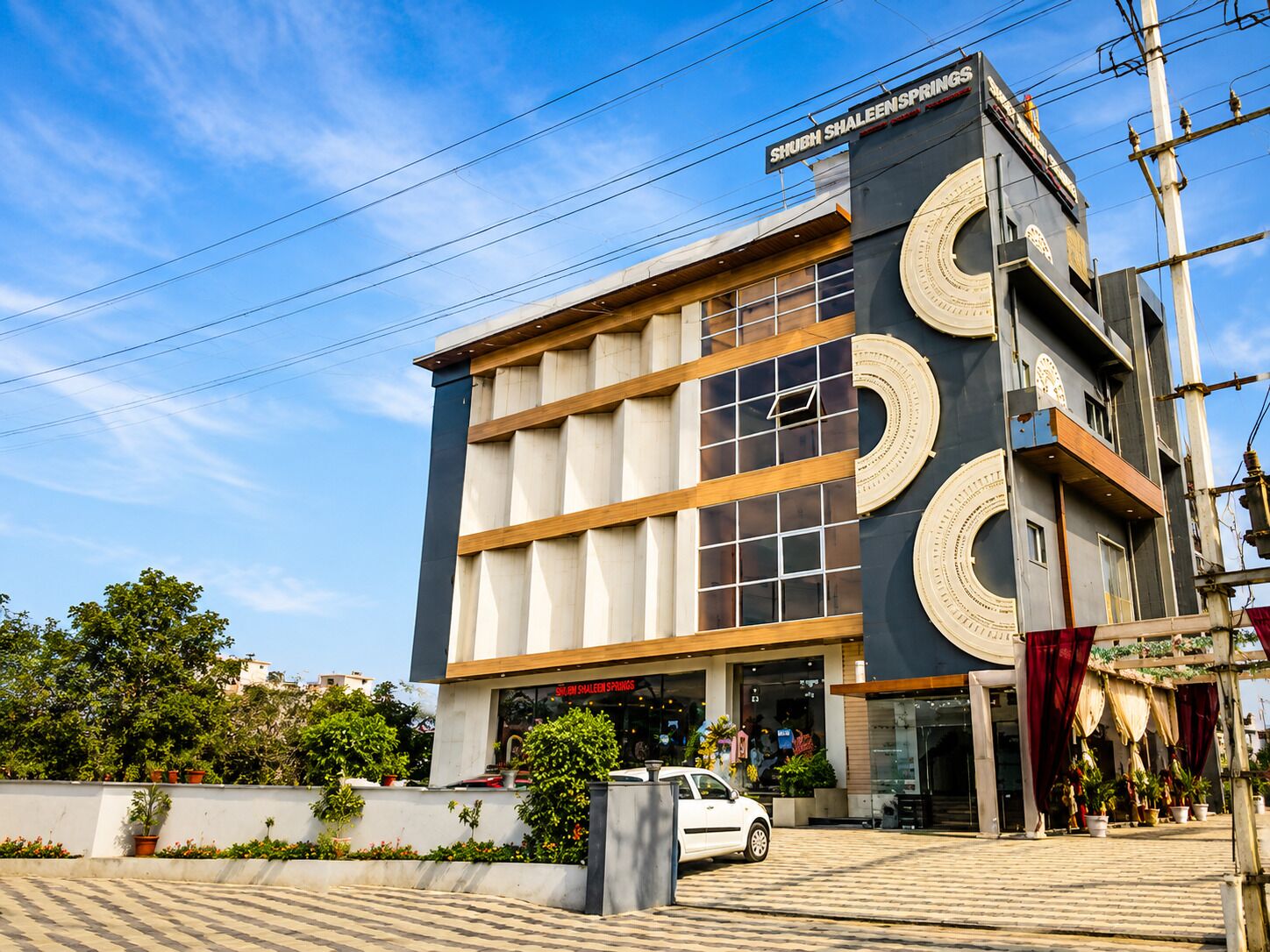 Un edificio moderno con un letrero destacado que dice 'SHUBH SHALEEN SPRINGS'.