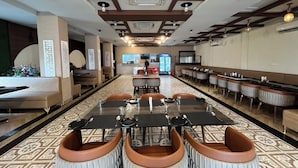 Un restaurant avec un long comptoir, des banquettes et un sol à motifs.