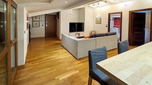 Una sala moderna con un sofá, un televisor y una mesa de comedor.