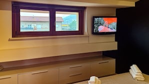 Un baño con ventana, televisor de pantalla plana y una toalla sobre la encimera.