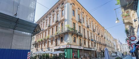 Un immeuble à plusieurs étages, avec un restaurant au rez-de-chaussée et une devanture visible depuis la rue.