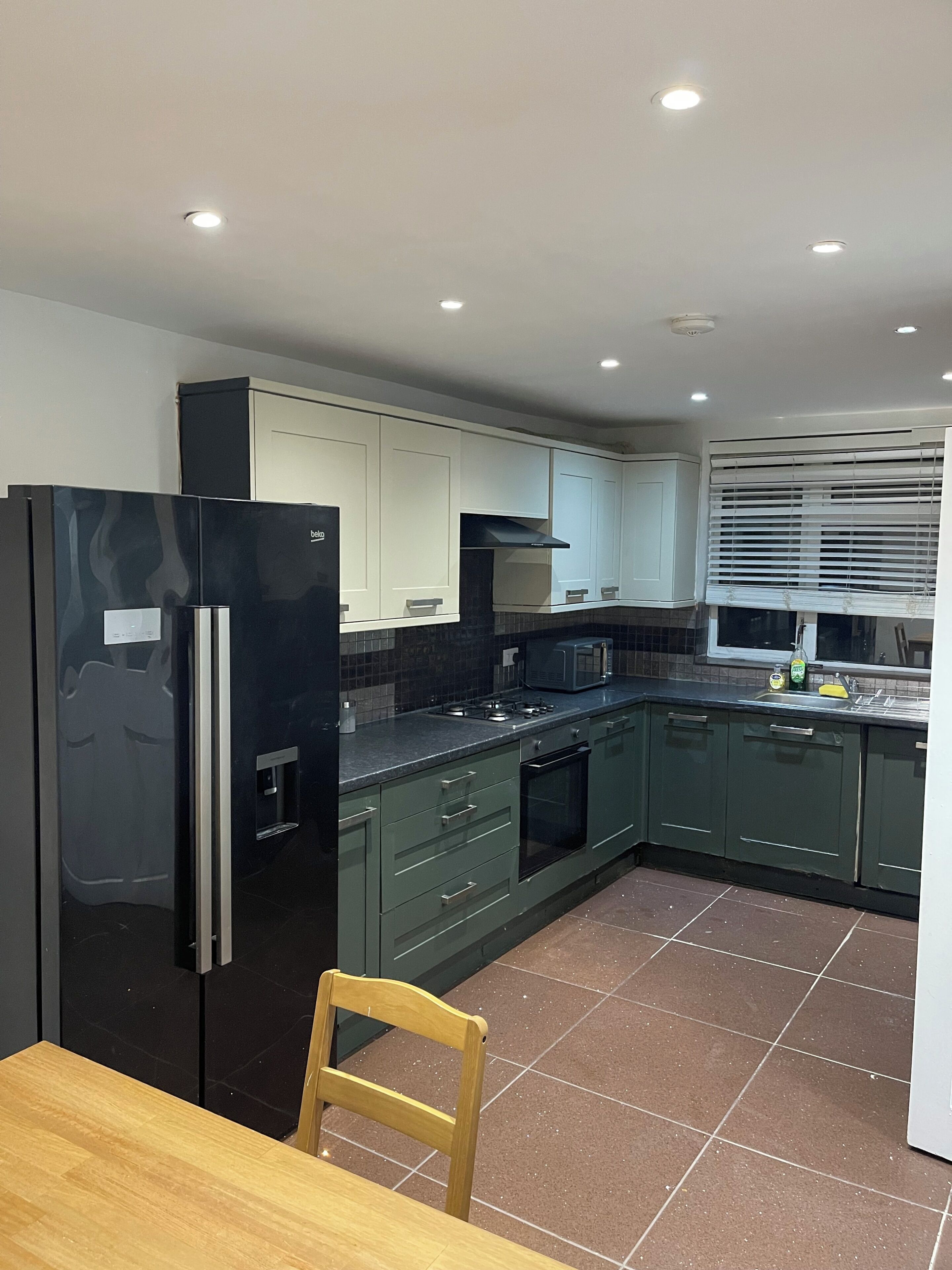A kitchen with a refrigerator, microwave, stove, and oven.