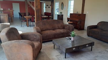 A living room with a brown sofa set, a coffee table with a vase, and a wooden bench.