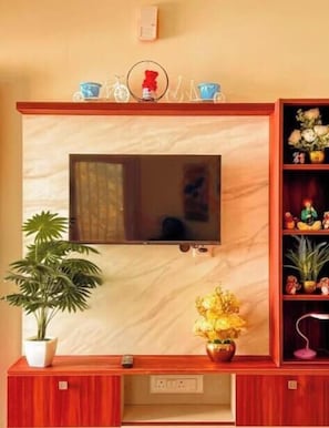 Un televisor montado en la pared con un mueble de madera debajo.