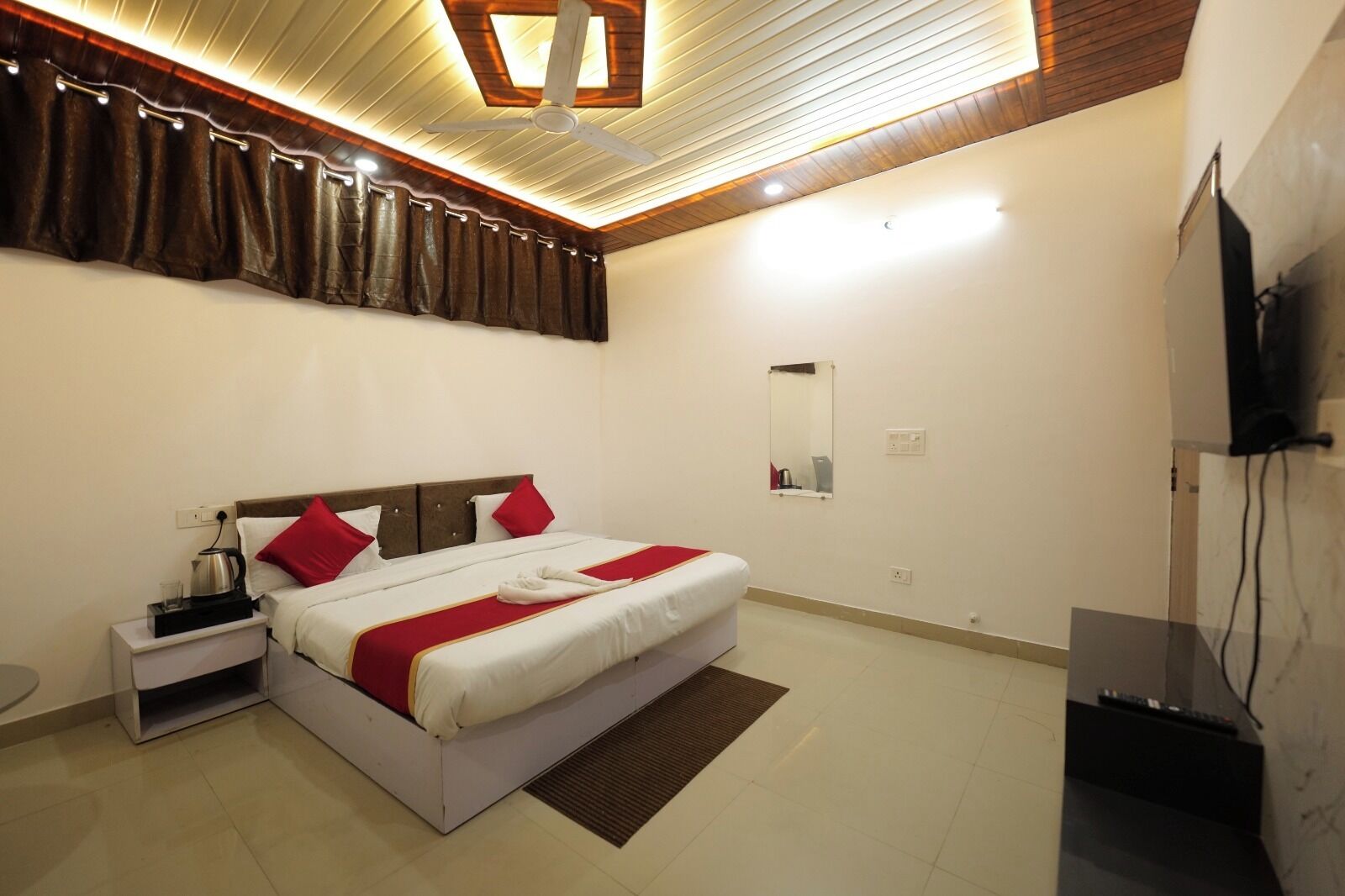 A hotel room with a bed, bedside table, and a television.