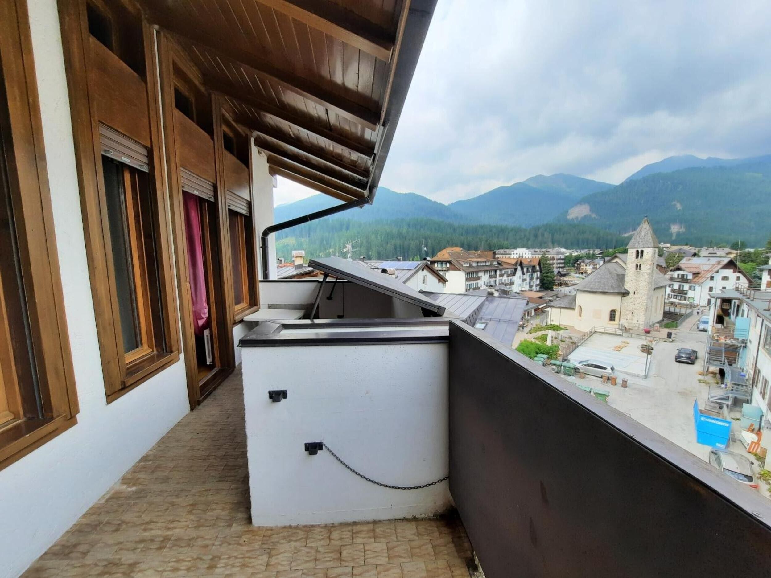 Un balcone con vista su una città e montagne.