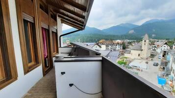 Un balcone con vista su una città e montagne.