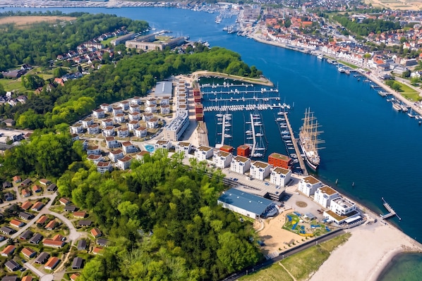 A marina with multiple docks and boats, surrounded by residential buildings and greenery. - Dünenvilla 10, Apartment 04 (Lübeck-Travemünde)
