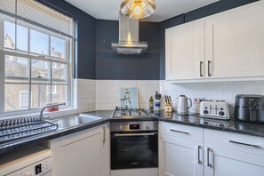 Une cuisine moderne équipée d’une cuisinière à gaz, d’un four et d’un grille-pain de la marque Breville.