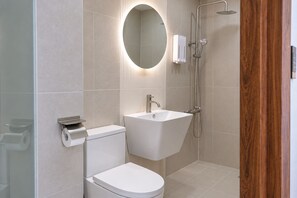 Ein modernes Badezimmer mit Toilette, Waschbecken und Dusche.