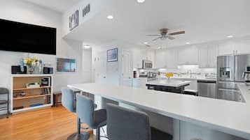 A modern kitchen with white cabinetry, a central island, and a built-in oven.