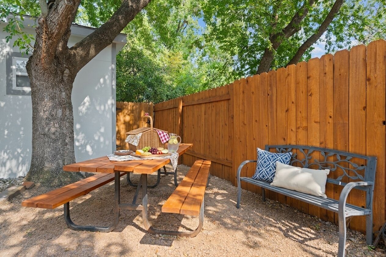 A picnic setup with a wooden table, benches, and a bench with cushions.