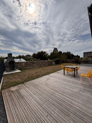 A wooden deck with a barbecue grill and outdoor seating. - Holiday Home 'Gîte 6 Personnes' with Private Terrace, Private Garden and Wi-Fi (Heugueville-sur-Sienne)