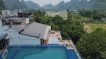 A rooftop pool with a view of a mountainous landscape.