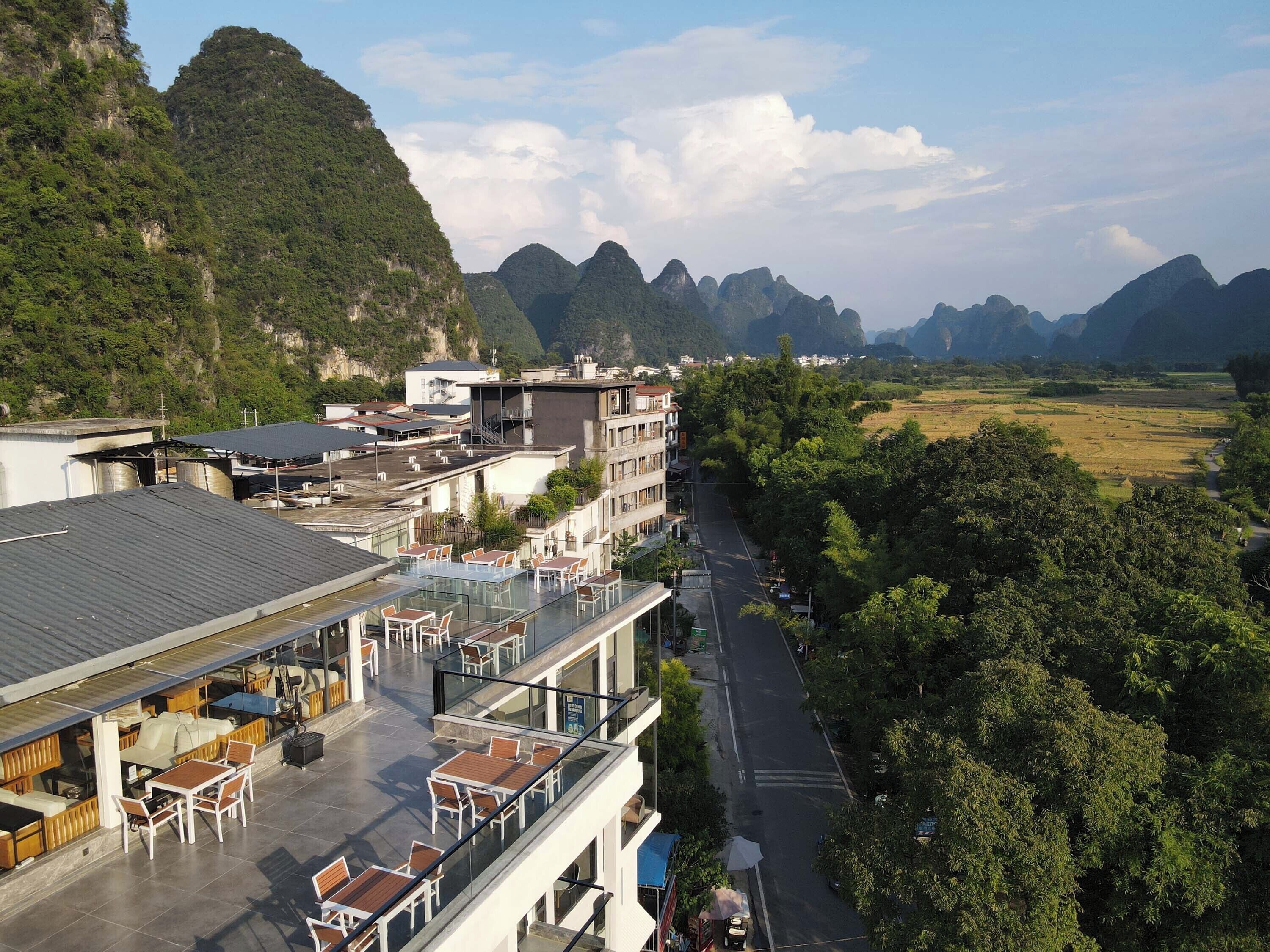 A hotel with outdoor seating overlooking a valley and mountains.