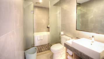 A modern bathroom with a glass shower enclosure, a toilet, and a sink with a marble countertop.