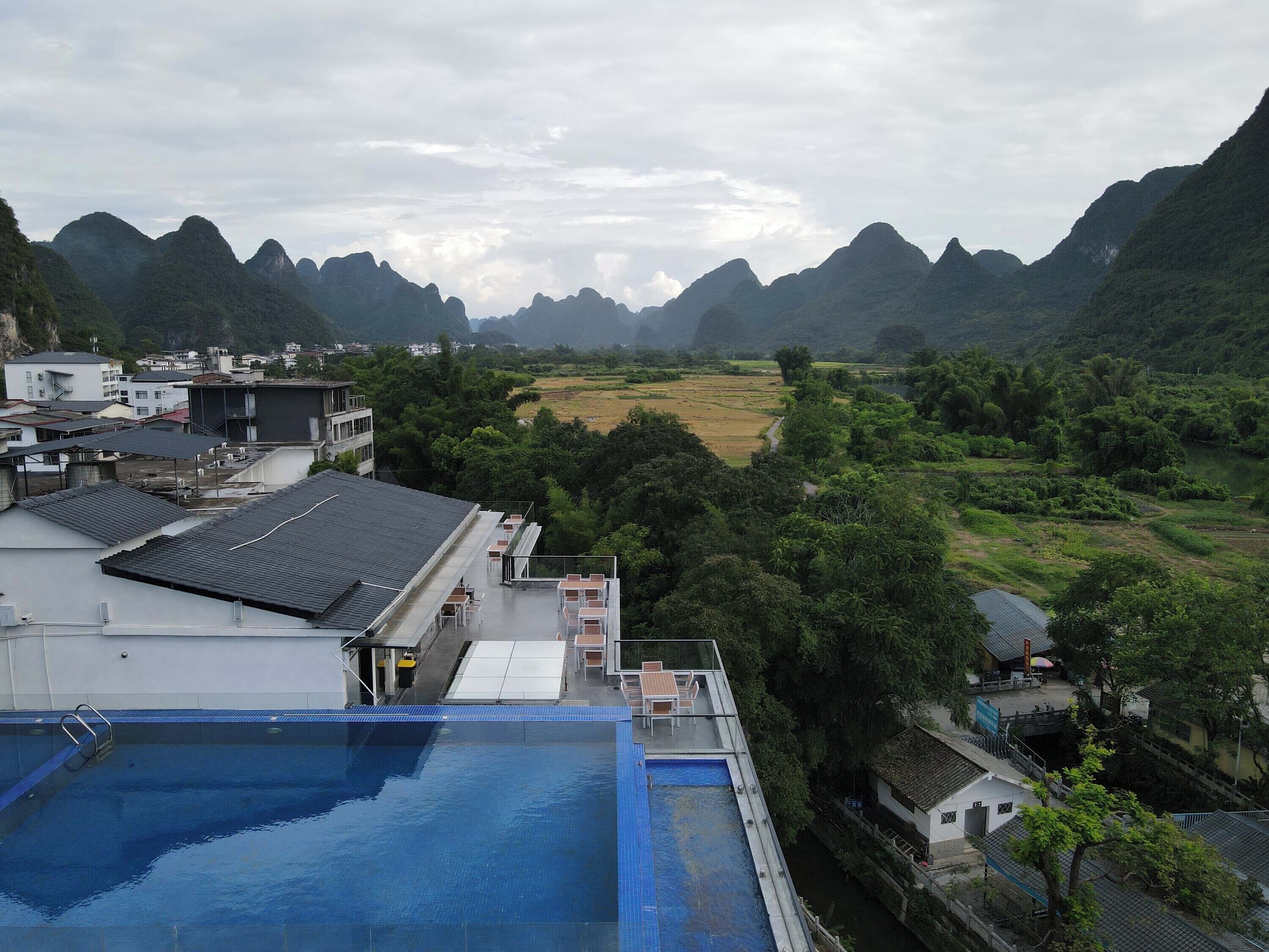 A swimming pool with a view of a mountainous landscape and residential buildings.