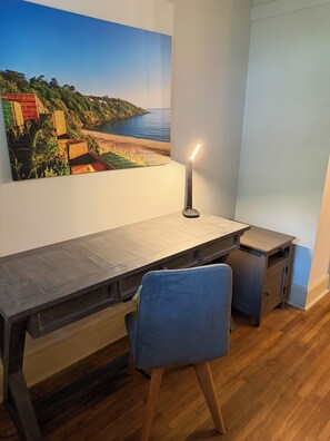 A study area with a desk, chair, and a lamp.