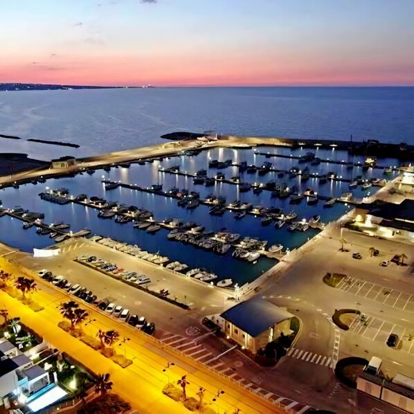 A marina with boats docked, a parking area, and a building with a blue roof. - An apartment in the heart of the village where you can enjoy your family vacation. (Montenero di Bisaccia)