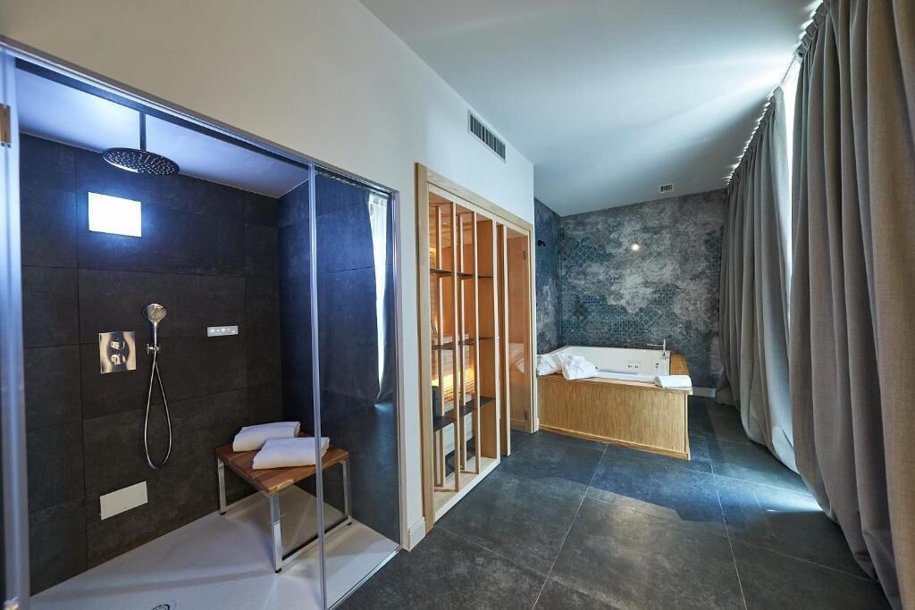 Un bagno moderno con doccia, vasca e un mobile lavabo con specchio.