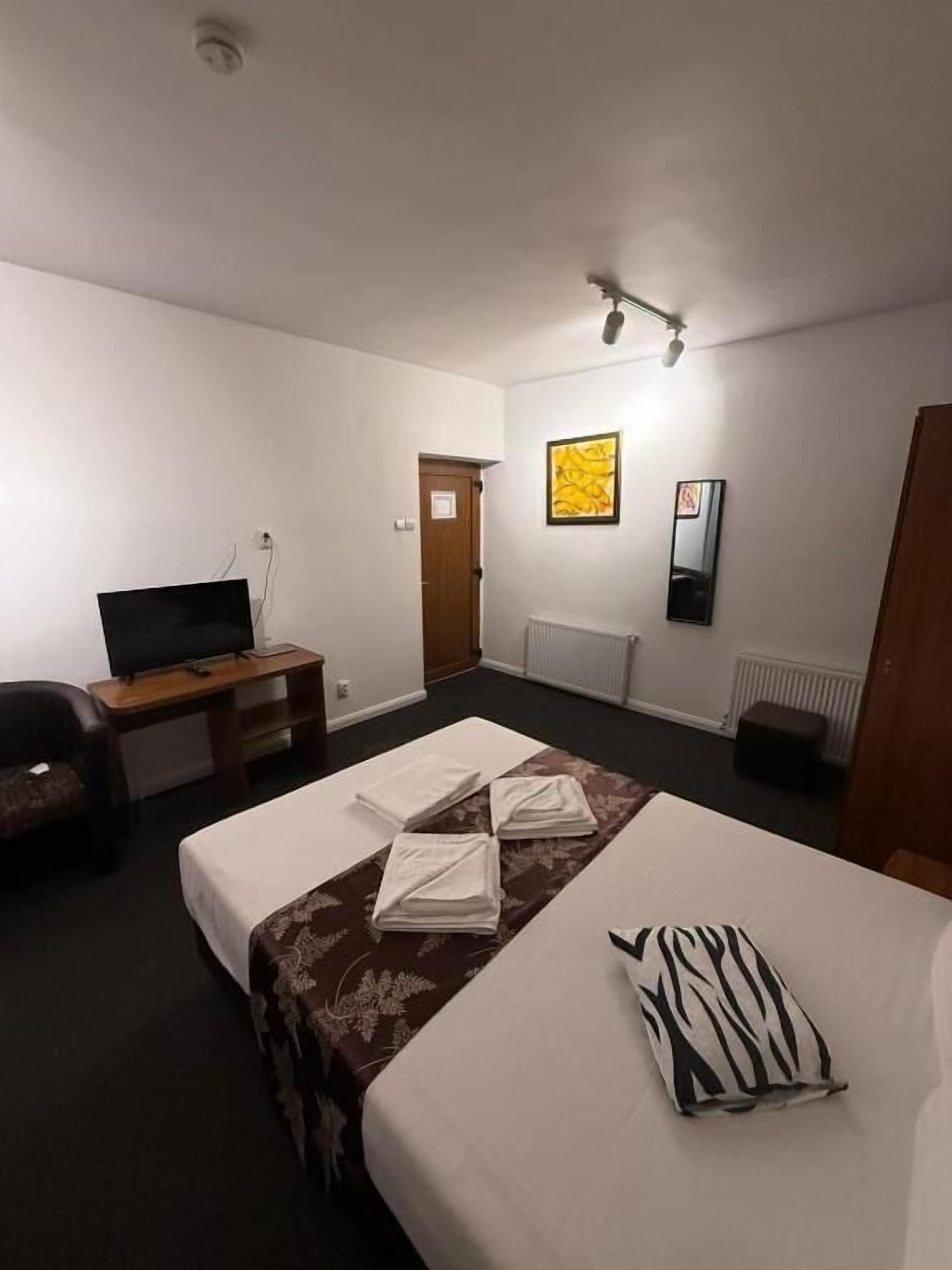 Une chambre d’hôtel équipée d’un lit, d’un bureau, d’une chaise, d’une télévision et d’un radiateur.