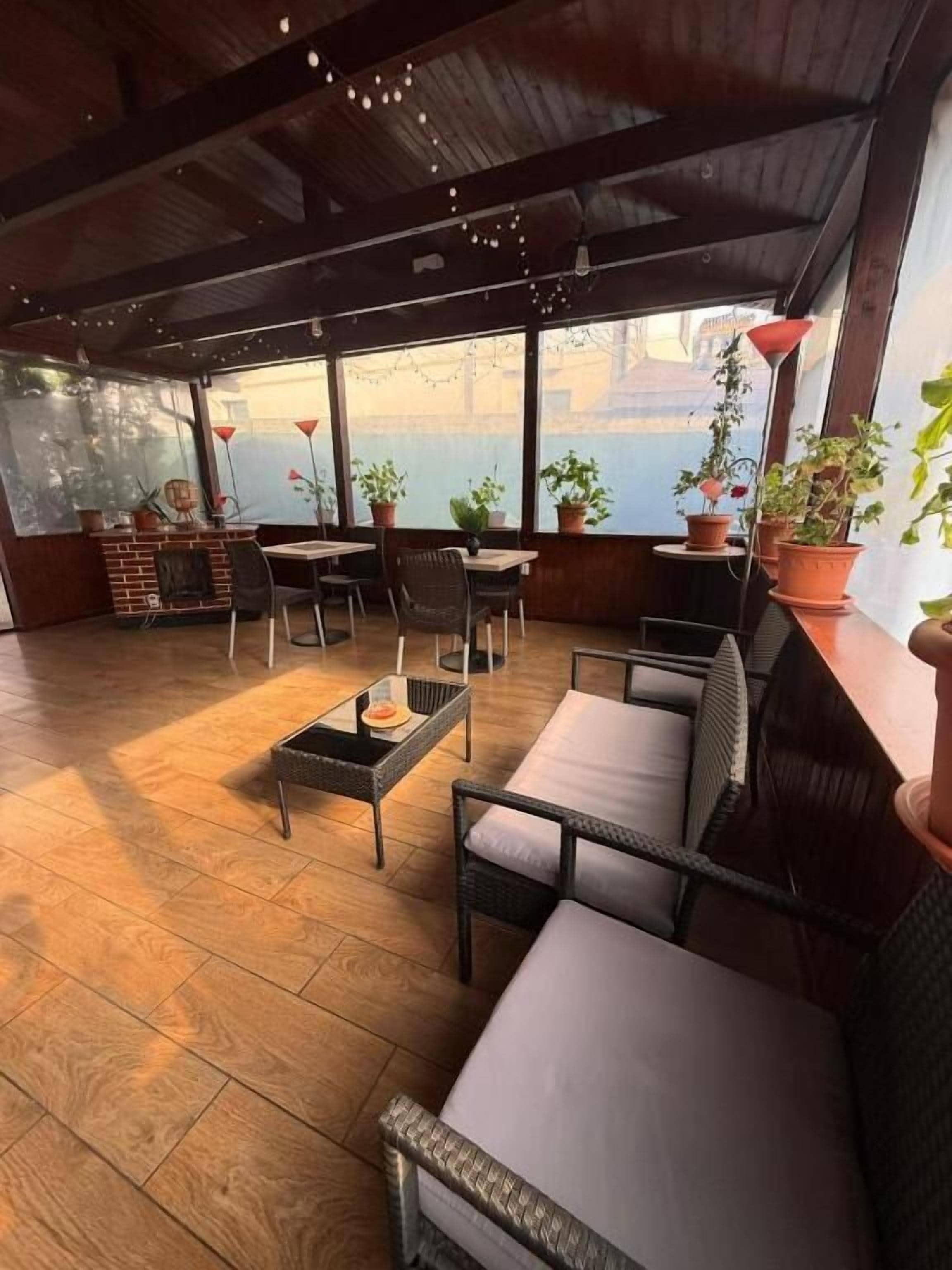 Un espace extérieur aménagé avec un sol en bois, des meubles en osier et des plantes en pot.