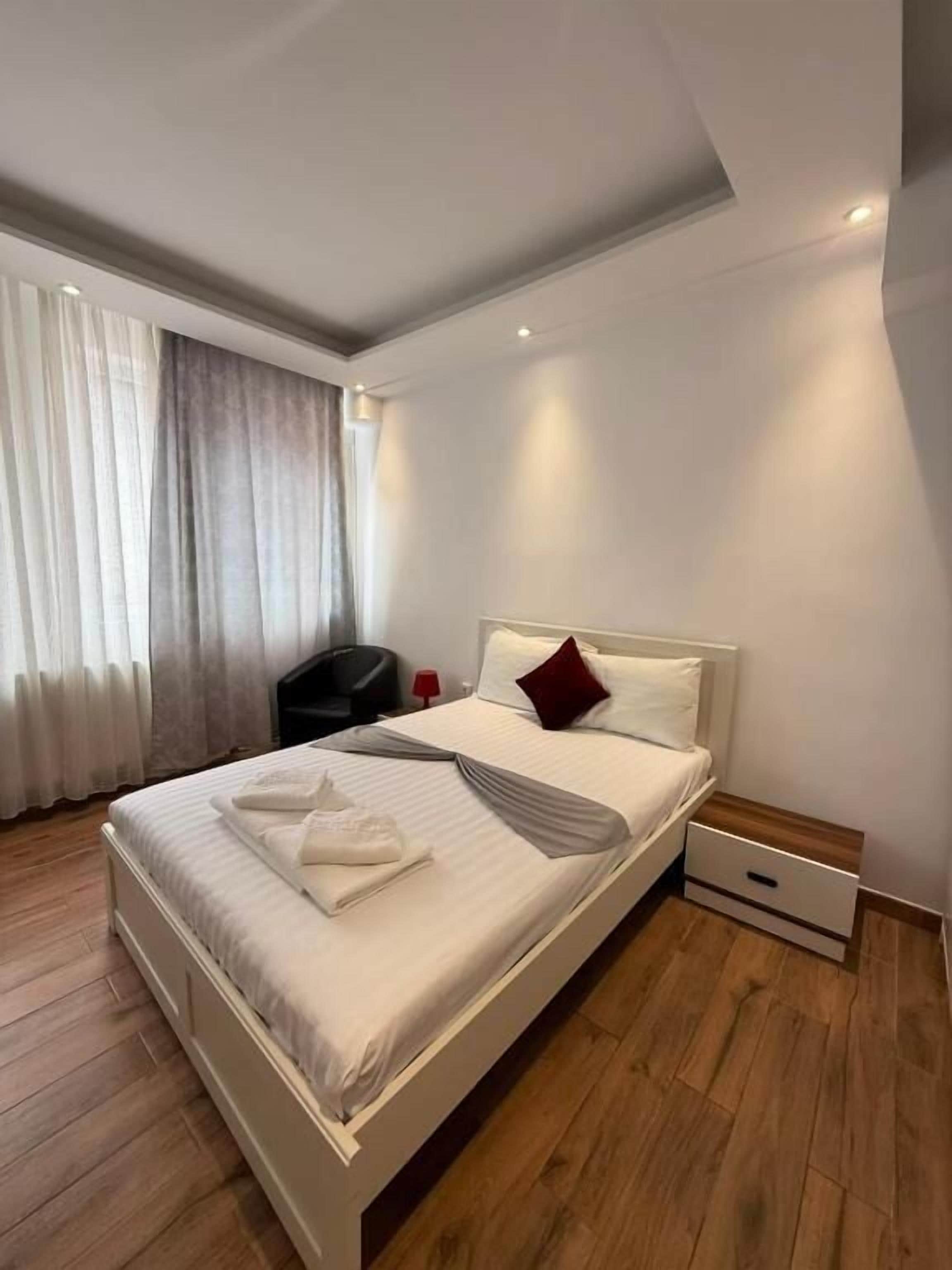 Ein Schlafzimmer mit einem Bett, einem Nachttisch und einem Sessel.