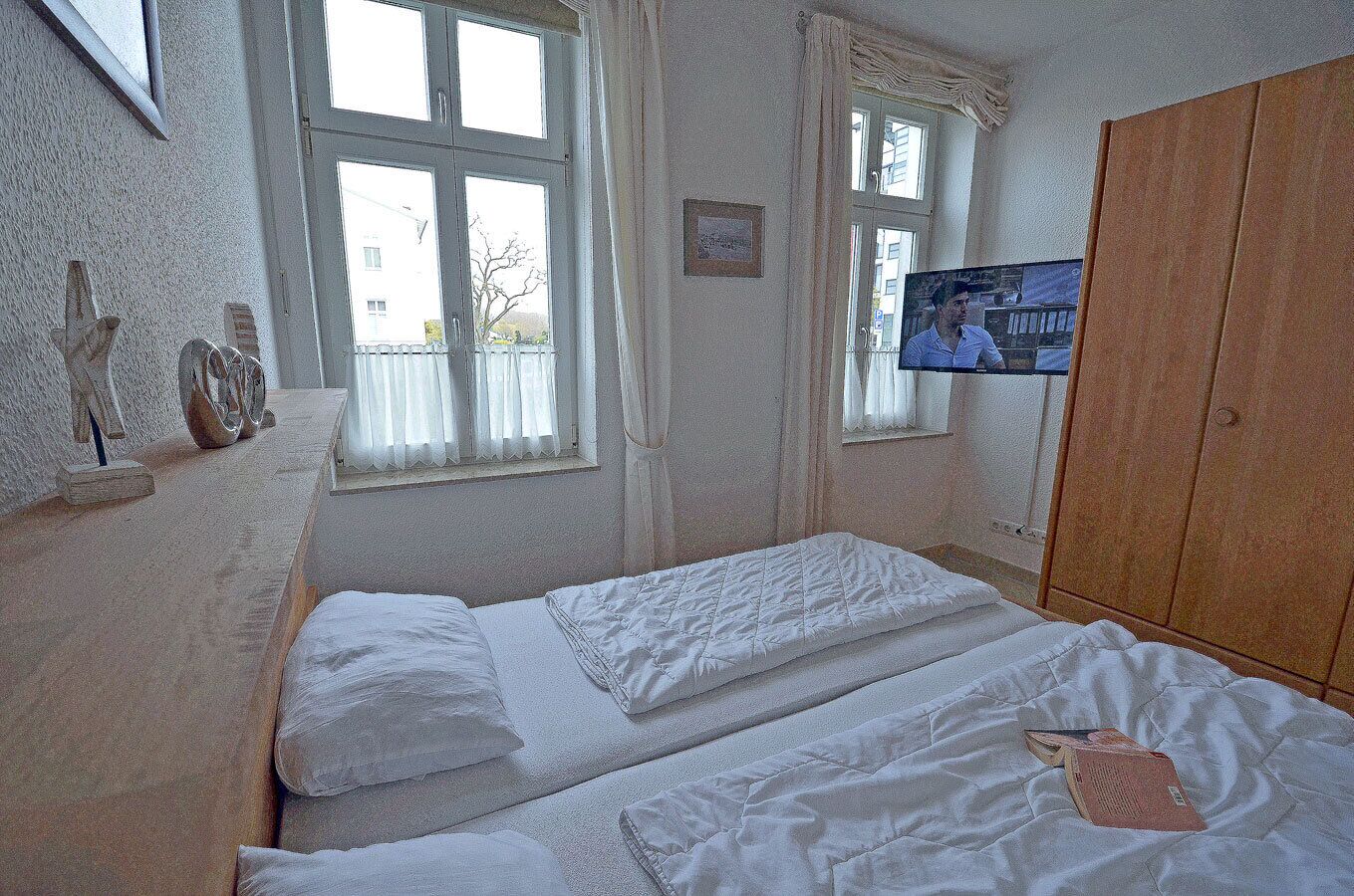 Ein Zimmer mit einem Bett, einem Fernseher und einem Kleiderschrank.