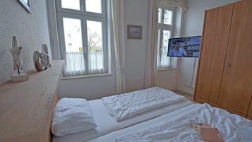 Ein Zimmer mit einem Bett, einem Fernseher und einem Kleiderschrank.
