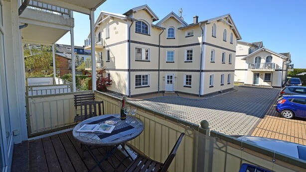 A balcony with a table, a bottle of champagne, and a newspaper. - Just 35 meters from the sandy Baltic Sea beach, Wi-Fi, 2 bedrooms, sleeps up to 5 people, with a balcony (Glowe)