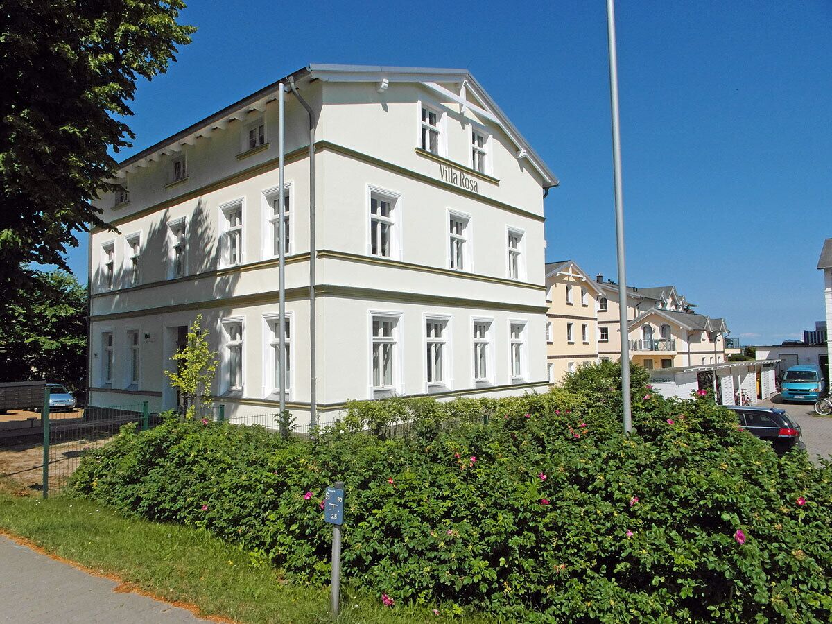 A multi-story building with a sign 'Villa Rosa' on the facade.