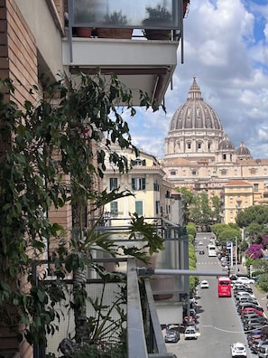 A street view with a large historical building with a dome in the background. - Rome, Vatican City — Elegant apartment with a view of St. Peter's Dome (Roma)
