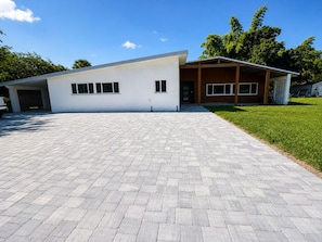 A modern two-story house with a paved driveway and a covered garage. - Punta Gorda Paradise – Spacious 4-Bedroom Getaway (Punta Gorda)