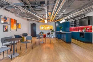 Ein modernes Interieur mit einer Neonreklame mit dem Schriftzug 'DREAM', Holzboden und einer Bar mit roten Fliesen.